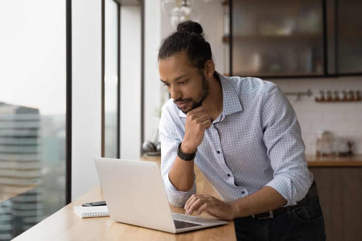 Man looking at his investments on laptop